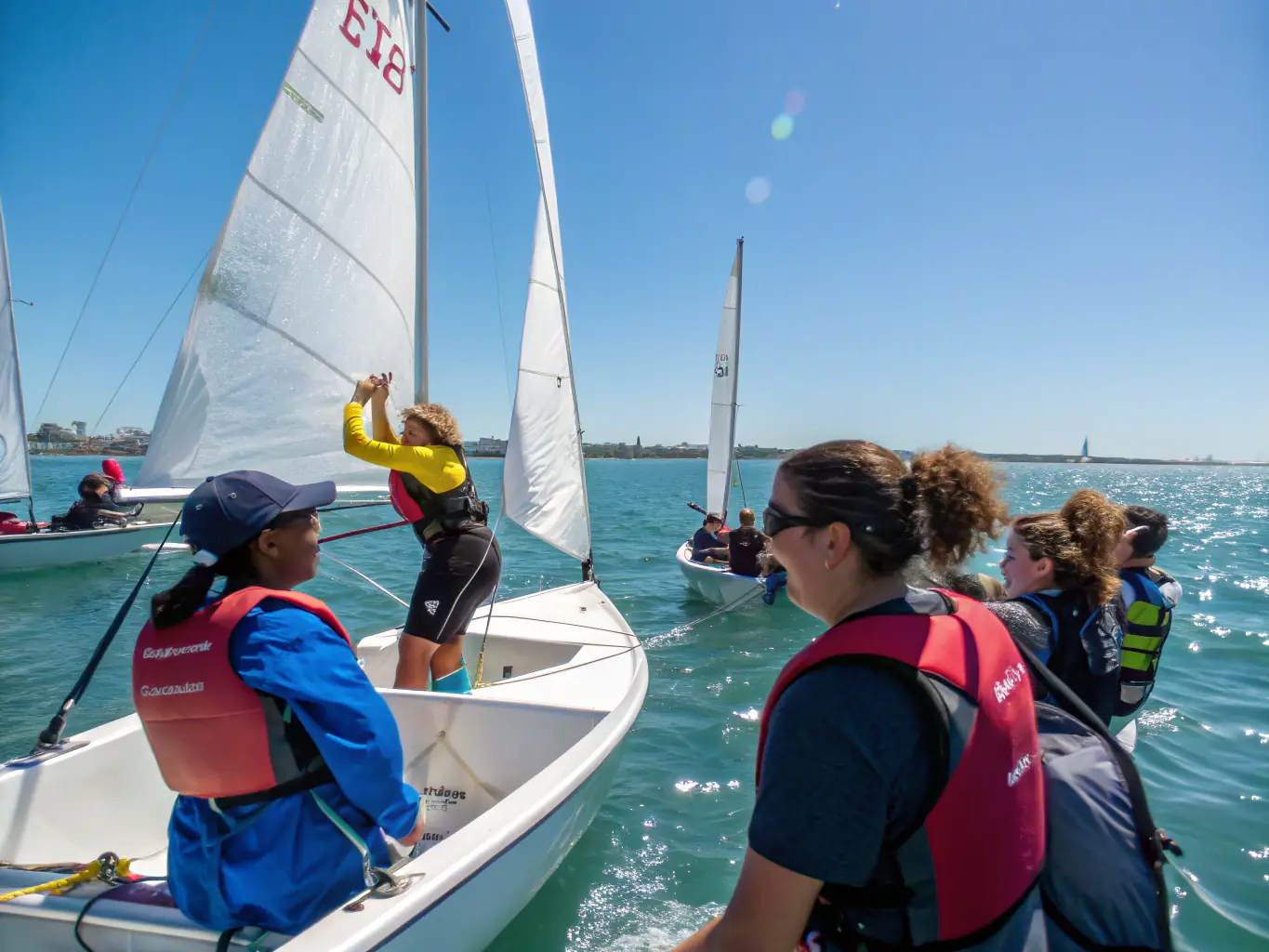A group of people sailing recreationally on a sunny day, with clear blue water and a vibrant sailboat in the foreground, showcasing the joy of leisure sailing.